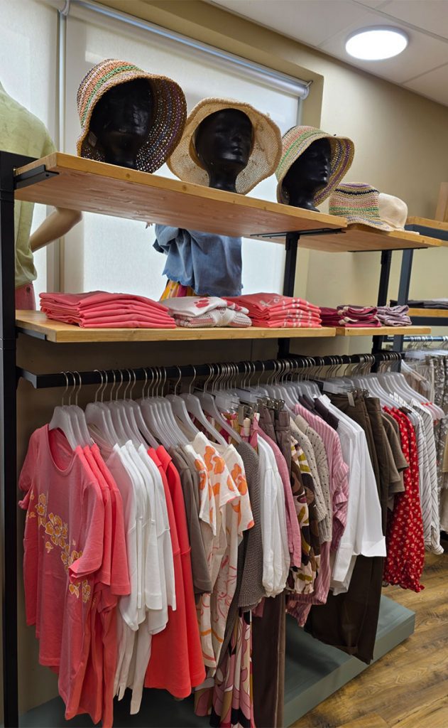 Präsentation der Damen-Sommerkollektion im Jeans House Olching mit Strohhüten, Shirts und leichten Sommeroutfits.