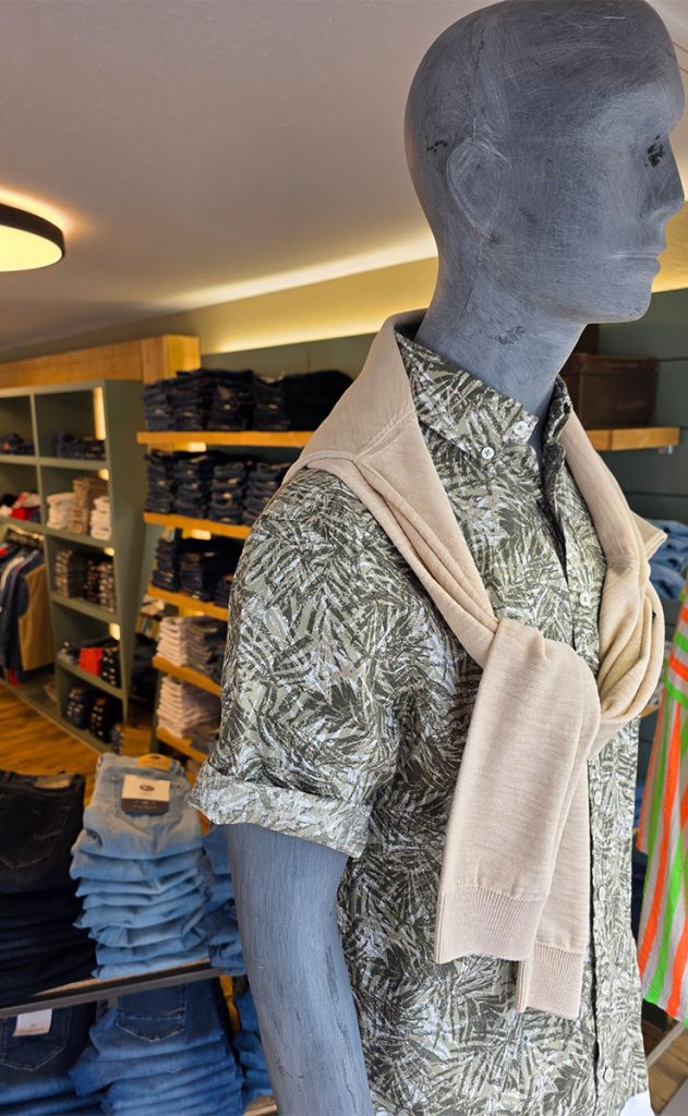 Herrenhemd mit Blätterprint und lässig über die Schultern gelegtem Pullover im Jeans House Olching.